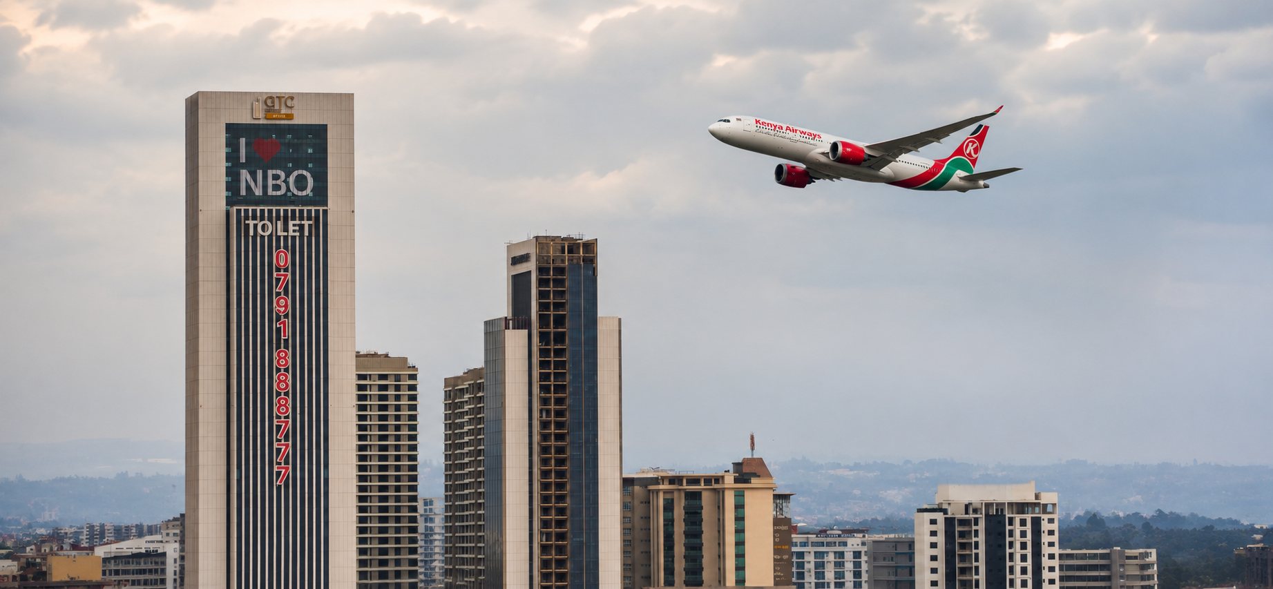 A Kenya Airways jet climbing over the Nairobi skyline